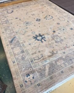 A light-colored area rug with delicate blue and purple floral patterns, available at Yas Rugs in Lexington, KY.