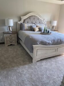 A cozy bedroom featuring new light gray wall-to-wall carpet from Independent Flooring in Eau Claire, WI