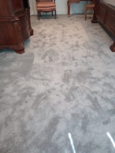 A bedroom featuring light gray patterned carpet installed by Carpet World Baton Rouge, LA.