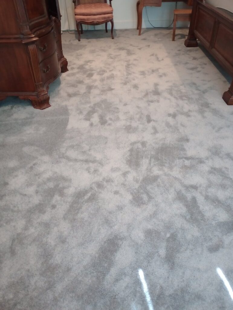 A bedroom featuring light gray patterned carpet installed by Carpet World Baton Rouge, LA.