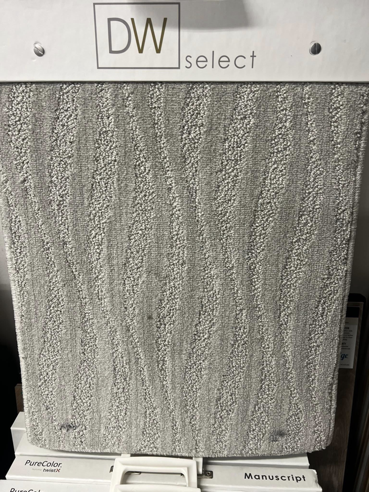 A close-up of a light gray wavy pattern carpet sample at West Michigan Flooring & Interiors in Byron Center, MI.