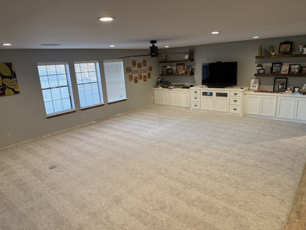 A spacious living room featuring a new light grey carpet installed by Floor Coverings International Metro OKC in Moore, OK.