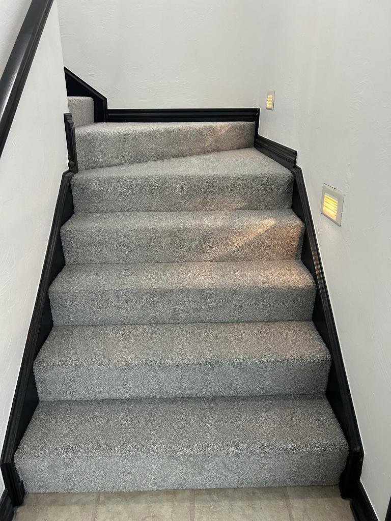 A newly installed light grey carpet on a staircase by Floor Coverings International Metro OKC in Moore, OK.