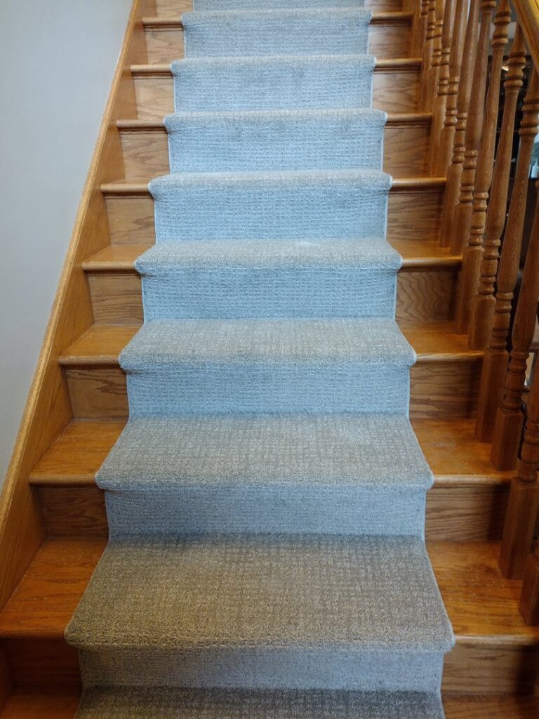 Newly installed light grey carpet on stairs by New City Carpet And Flooring, a professional carpet contractor in Chicago, IL