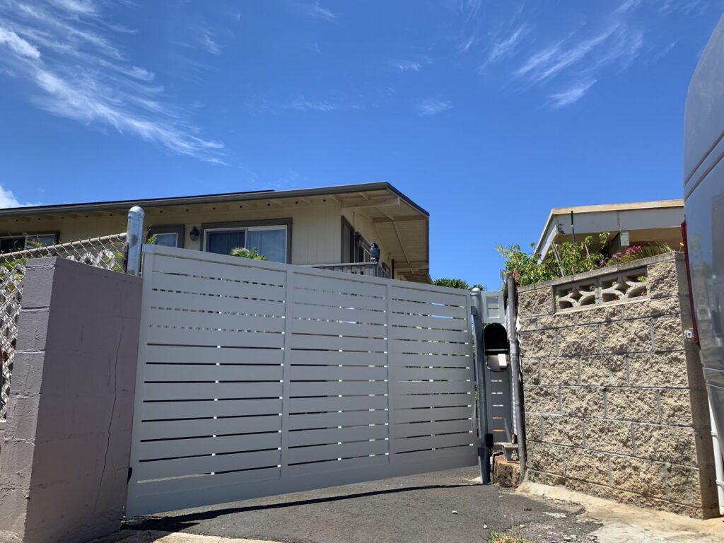 A light grey horizontal slat sliding gate installed for a residential property by A&D Services in Kapolei, HI.