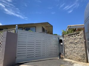 A light grey horizontal slat sliding gate installed for a residential property by A&D Services in Kapolei, HI.