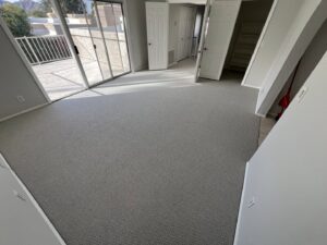 A bedroom featuring a new light grey patterned carpet installation by Canyon State Flooring in Queen Creek, AZ.