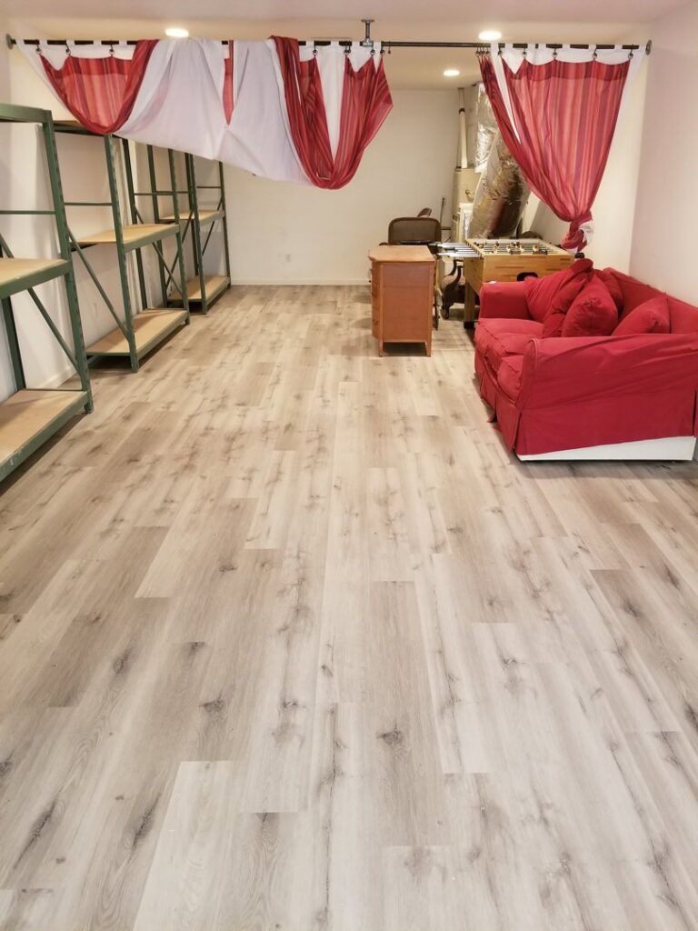 A room with newly installed light grey wood-look plank flooring, a completed project by LACarpetWarehouse in Los Angeles, CA.