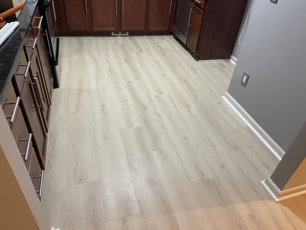 Newly installed light laminate flooring in a kitchen by Nations Best Flooring & Carpet Co. in Livonia, MI.