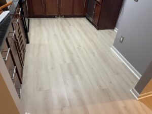 Newly installed light laminate flooring in a kitchen by Nations Best Flooring & Carpet Co. in Livonia, MI.