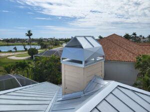 A light-colored modern chimney cap installed on a metal roof by SWFL Chimney Caps Inc. in Fort Myers, FL.