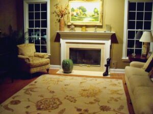 A light-colored oriental rug illuminating a cozy living room at night, expertly placed by Brandon Oriental Rugs in Furlong, PA.