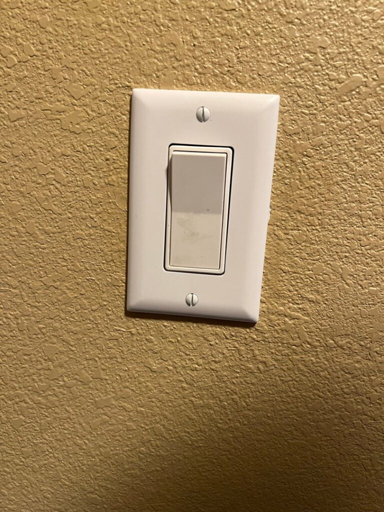 A clean, newly installed light switch on a textured wall by AC-DC Electric in Severance, CO.