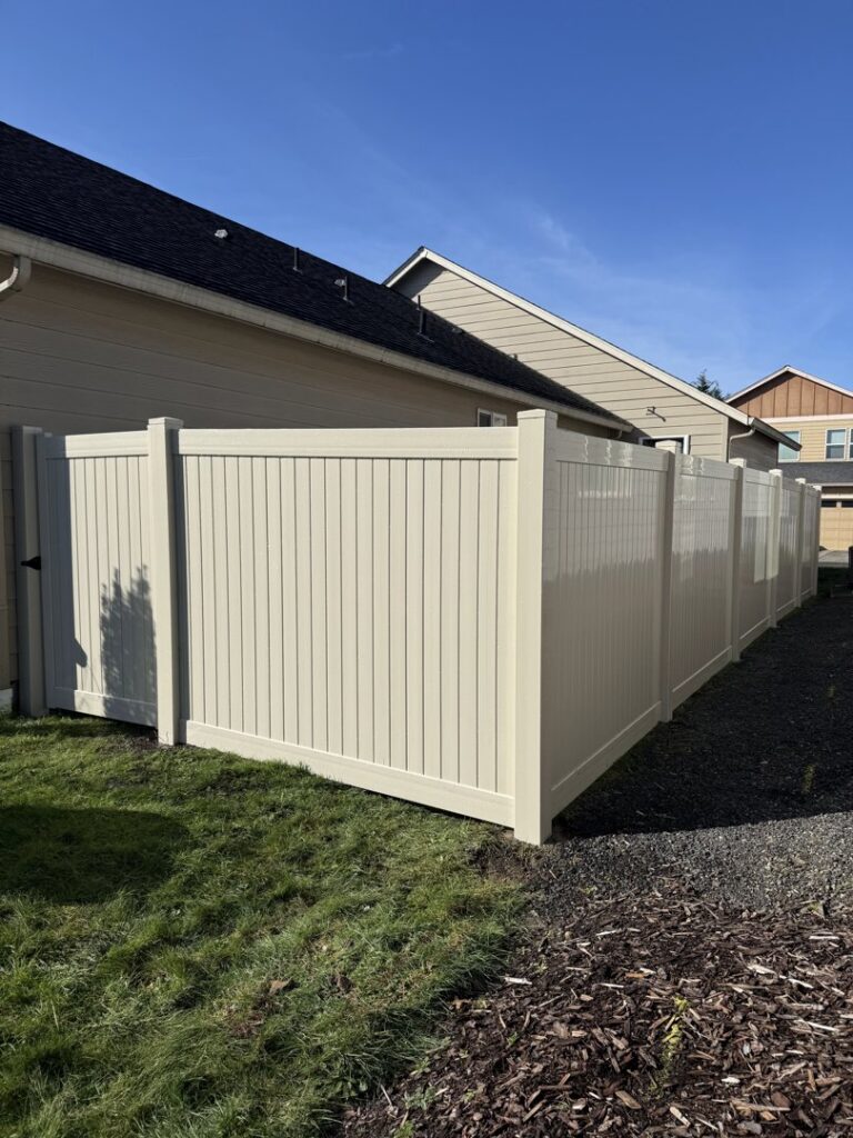 A light-colored vinyl privacy fence installed around a residential backyard by Clark County Fence LLC in Vancouver, WA.