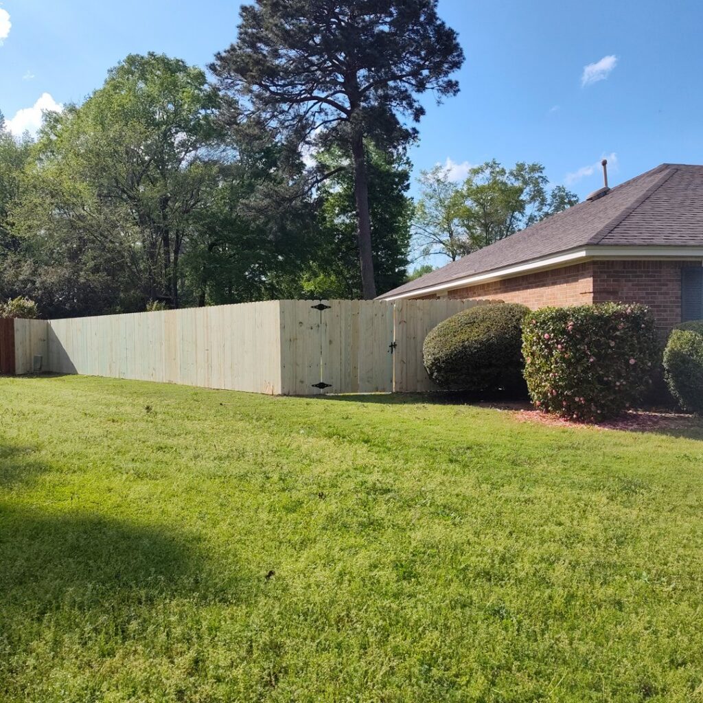 A light-colored wood privacy fence with a gate, providing security and style from The Fence Dudes in Birmingham, AL.