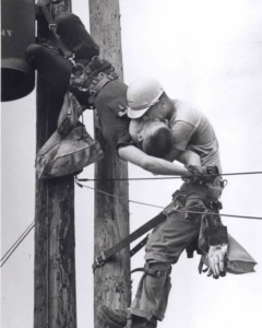 Two linemen working on a utility pole, performing electrical work for AJ Electric in San Francisco, CA.