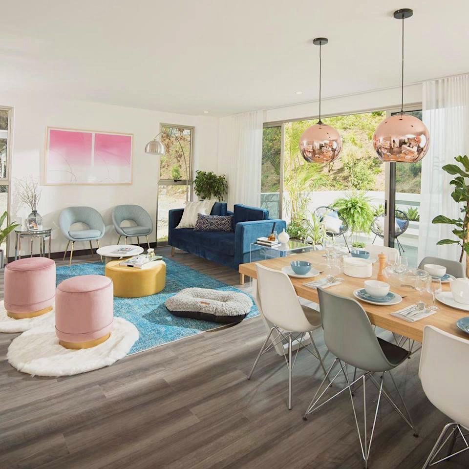 A spacious living and dining area featuring wood-look flooring and a blue area rug from Carpet World Baton Rouge, LA.