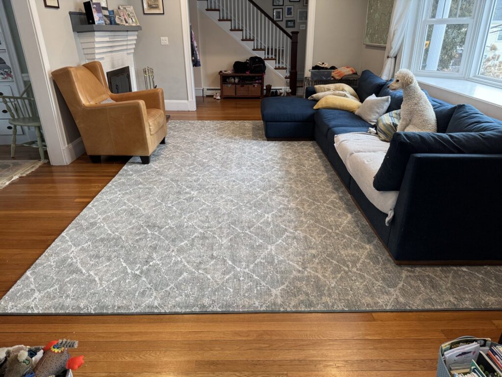 A beautifully installed area rug in a living room by Harry's Carpet One in Quincy, MA.
