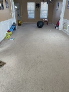 A spacious living room featuring a new light beige carpet installation by HM Bates Flooring & Remodeling in Matthews, NC.