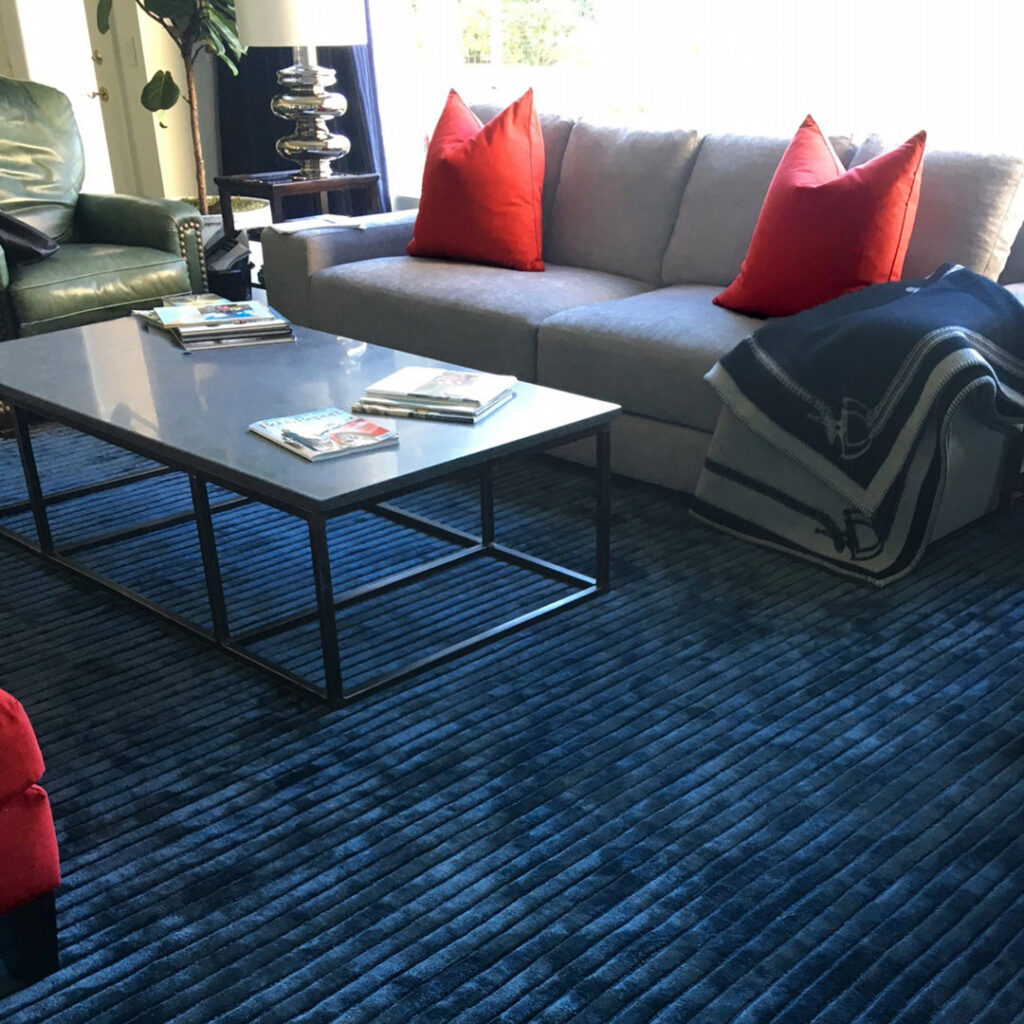 A living room featuring a modern blue ribbed carpet, installed by Odino Designs, llc in Portland, OR.