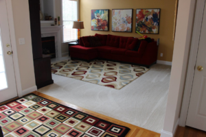 A living room with a large area rug and a freshly cleaned carpet underneath by Royal Carpet Care in West Babylon, NY.