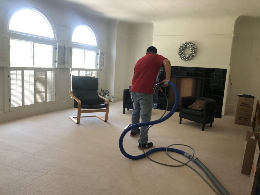 A professional cleaning a large living room carpet with a powerful cleaning wand for Dalia's Carpet Cleaning in San Francisco, CA.