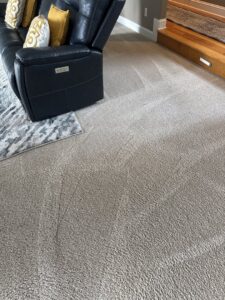 Living room carpet showing cleaning lines around a sofa after service by Jones Carpet Care LLC in Huntsville, AL.
