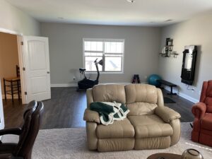 A living room area featuring new light grey carpet installed by Floorboys of Greenville in Greenville, SC.