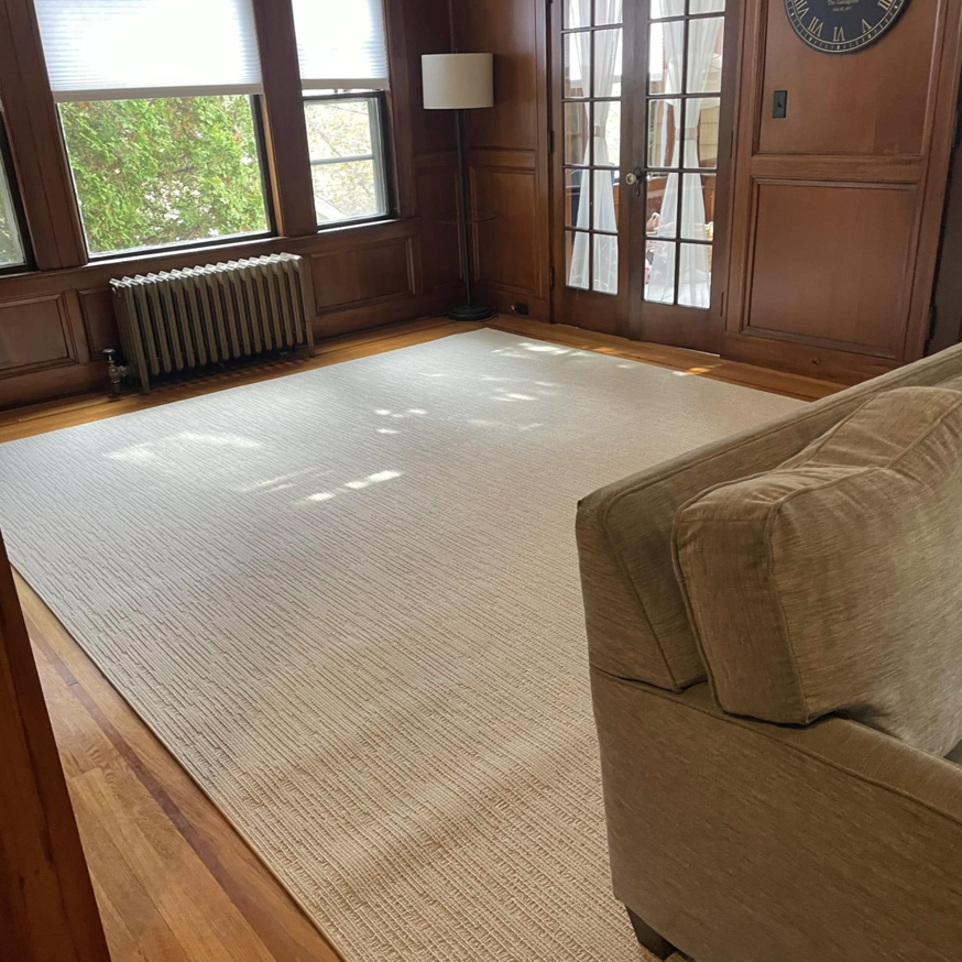 A large, light-colored carpet installed in a living room by J MIKE PONTE FLOOR COVERING in Lowell, MA.
