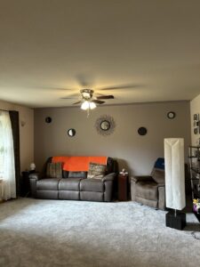 A comfortable living room showcasing a newly installed ceiling fan and wall sconces, expertly completed by Devaney Electric Co. in Lacey, WA.