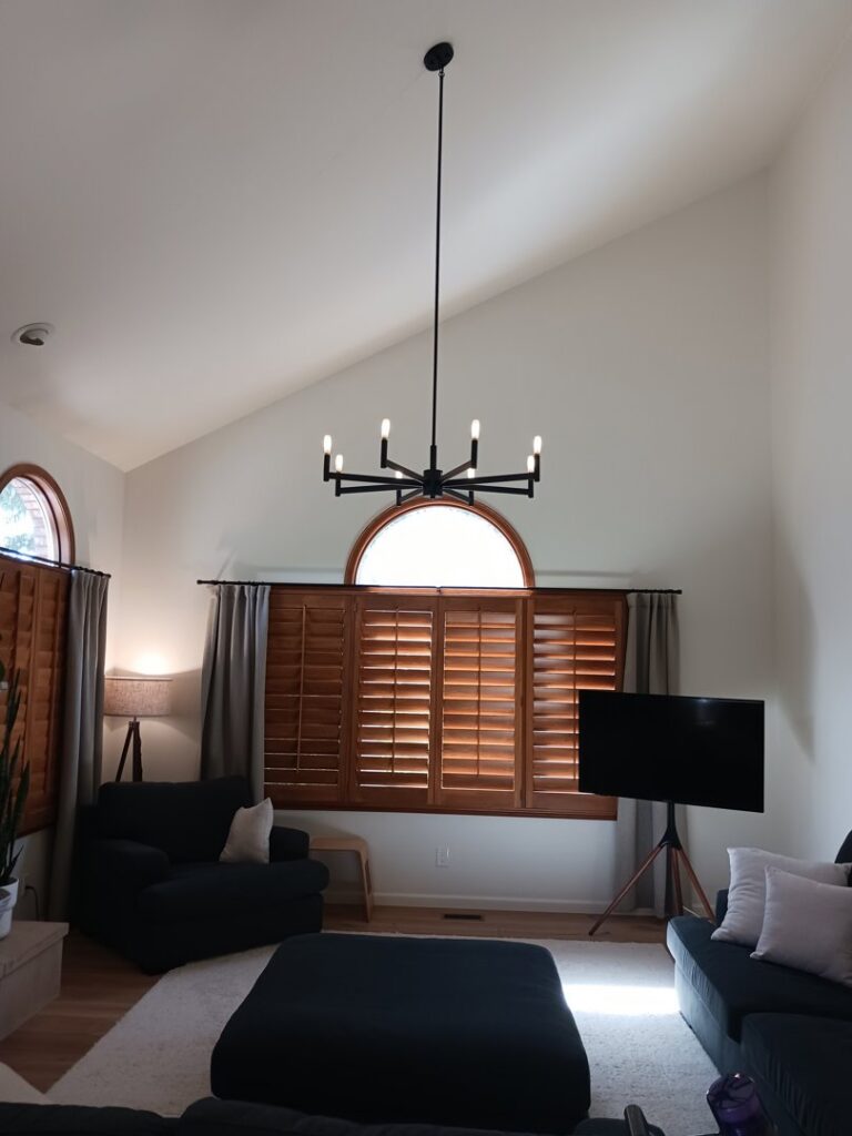 A modern chandelier installed in a living room with high vaulted ceilings by Midway Electric Inc. in Columbia, MO.