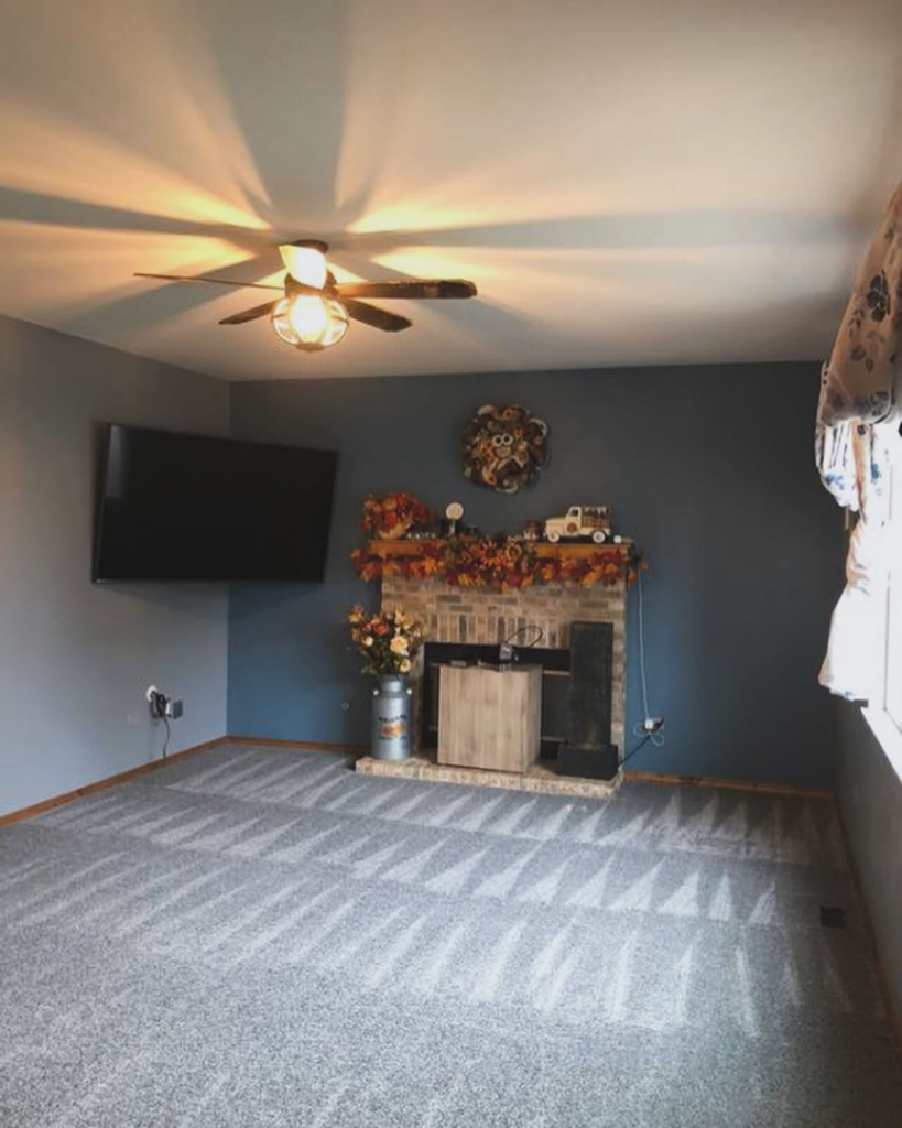 A cozy living room featuring a newly installed grey carpet by Rosas Carpet & Flooring in Shorewood, IL.