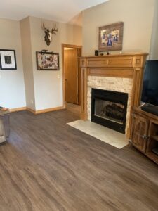 A living room featuring dark wood-look laminate flooring installed by Carpet Direct Brandon Burley in Muskogee, OK