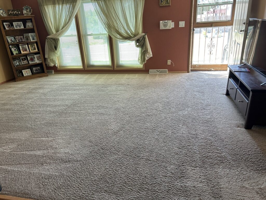 A living room with light brown carpet displaying fresh cleaning patterns by Pueblo's Best Carpet & Air Duct Cleaning in Pueblo West, CO.