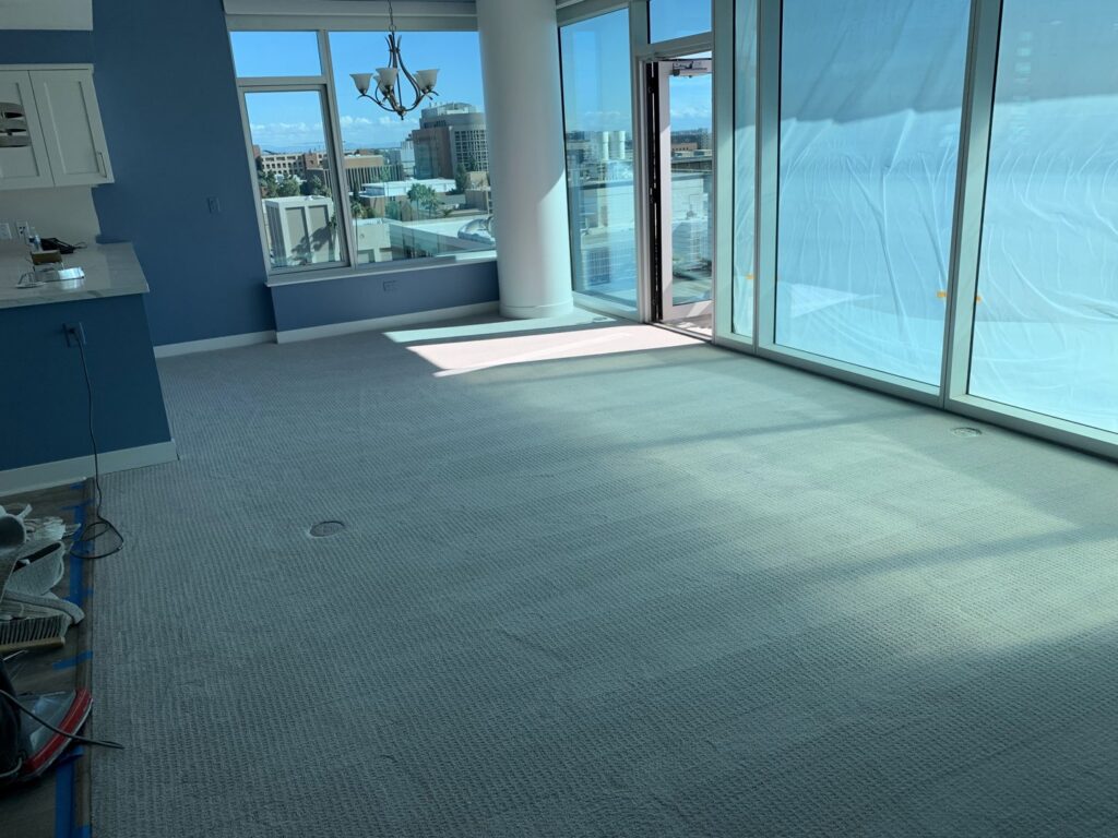 A spacious living room with new light grey carpet, professionally installed by Canyon State Flooring in Queen Creek, AZ.