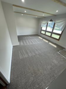 A living room featuring new grey carpet installed by CDK Flooring, LLC in Sheboygan, WI.
