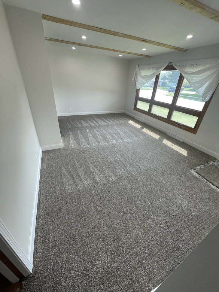 A living room featuring new grey carpet installed by CDK Flooring, LLC in Sheboygan, WI.