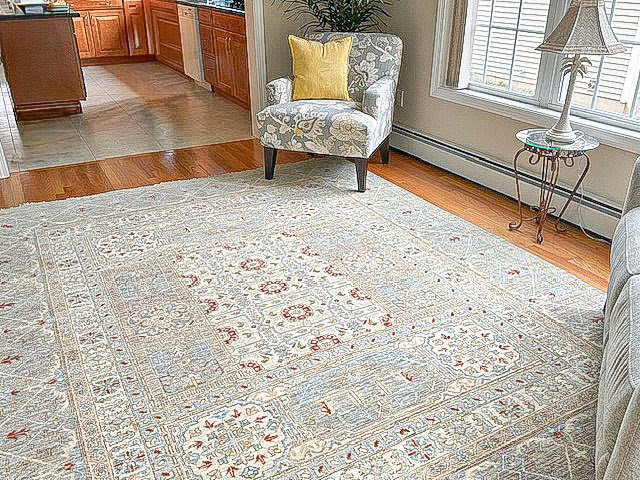 A large oriental style area rug beautifully placed in a living room by Kaoud Rugs in West Hartford, CT.