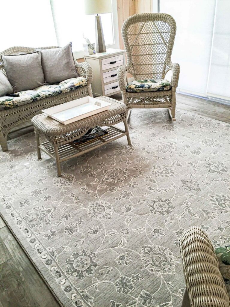 A light-colored patterned area rug beautifully placed in a living room by Kaoud Rugs in West Hartford, CT.