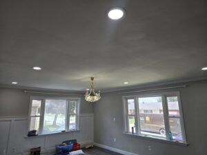 A living room featuring new recessed lighting and a chandelier installed by Be Bright Electric in Erie, PA.