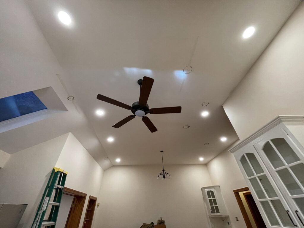 A living room with newly installed recessed lighting and a ceiling fan by Royal Electric Services in Raleigh, NC