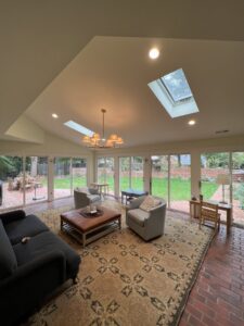 A living room with new recessed lighting and a decorative chandelier installed by Copper And Current Electrical Services in Greensboro, NC.