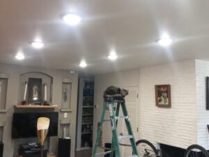 Living room with new recessed lighting installation by Intel-electric in Anchorage, AK, with a cat on a ladder