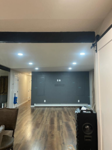 A modern living room with recessed ceiling lights and a wall prepared for a TV mount, installed by Jimenez Electric Inc in Denver, CO.