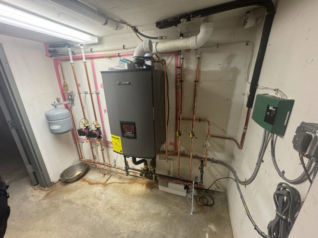 A Lochinvar water heater and boiler system with copper piping installed in a utility room by All Points HVAC in Worcester, MA.