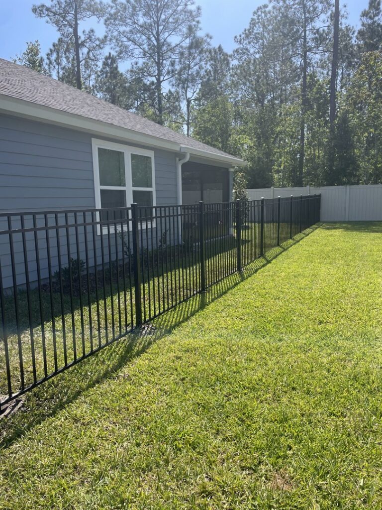 A long section of black aluminum fence installed next to a residential home by R&R Fence Services in Jacksonville, FL.