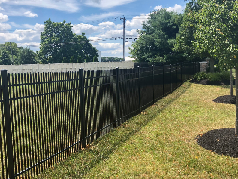 A long section of black aluminum fence defining a property boundary by Mercer Fence Company in Hamilton Township, NJ.