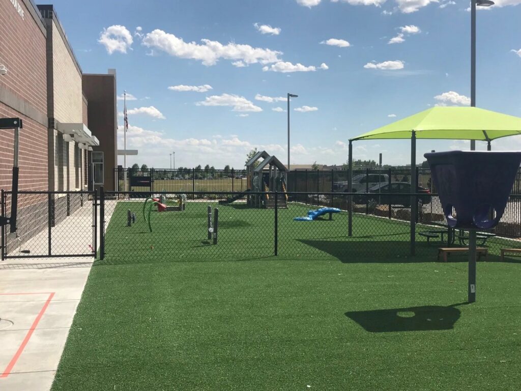 An extensive black chain-link fence surrounding a large school field, providing security and demarcation by Best Boy's Fencing in Fort Collins, CO.