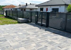A long black horizontal slat fence with an integrated gate, installed by Coastline Gate Repair in Los Angeles, CA.
