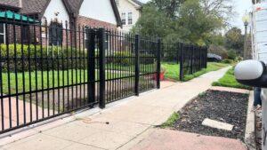 A long black iron fence with a matching gate, installed by Exclusive Custom Iron Works in Stockton, CA.